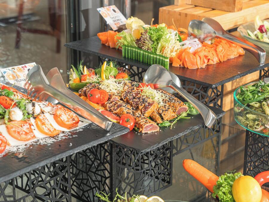 A buffet with various dishes including salads, grilled meats, and seafood.