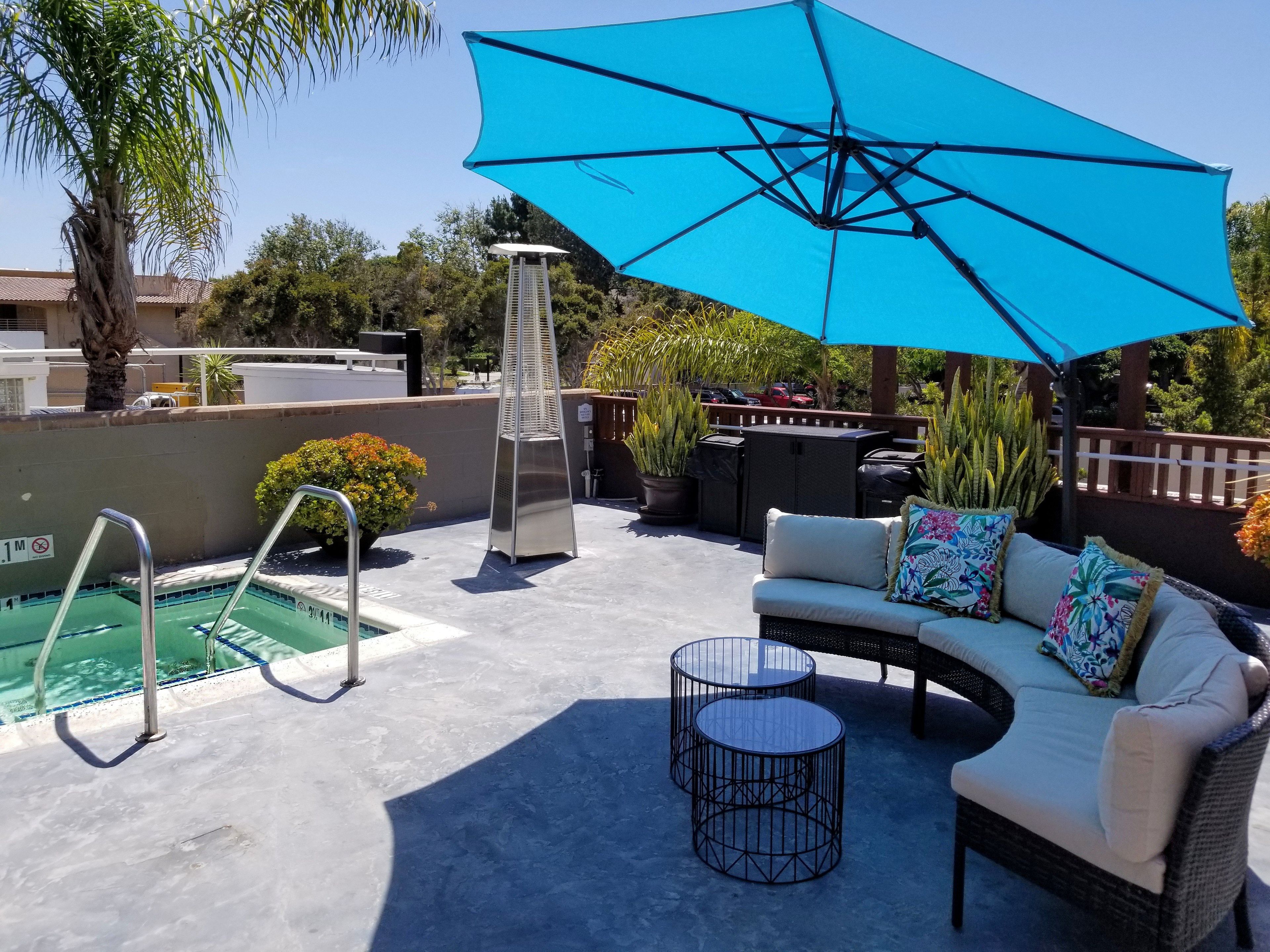 An outdoor patio with a pool, a barbecue area, and a seating arrangement.