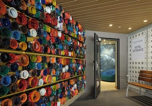 A wall of paint cans in various colors, a bench, and a sign indicating the hotel entrance. - voco Solana Beach-Del Mar by IHG (Solana Beach)