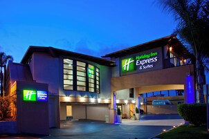 Un hotel Holiday Inn Express & Suites con diseño moderno, que destaca por su entrada y señalización.