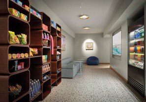A modern interior with a snack bar, seating area, and a refrigerator stocked with beverages. - Holiday Inn Express Solana Beach-Del Mar by IHG (Solana Beach)