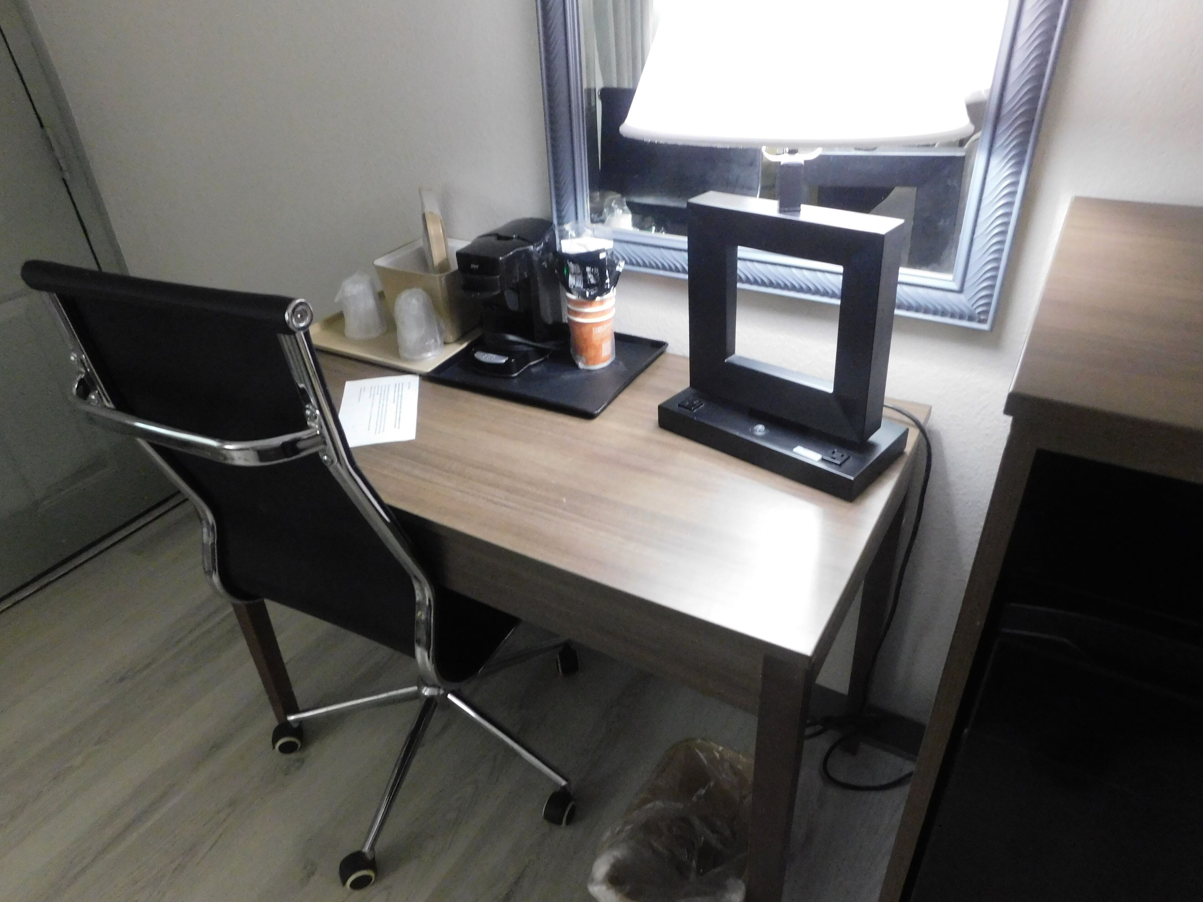 A desk with a laptop, a coffee cup, and a coffee machine.