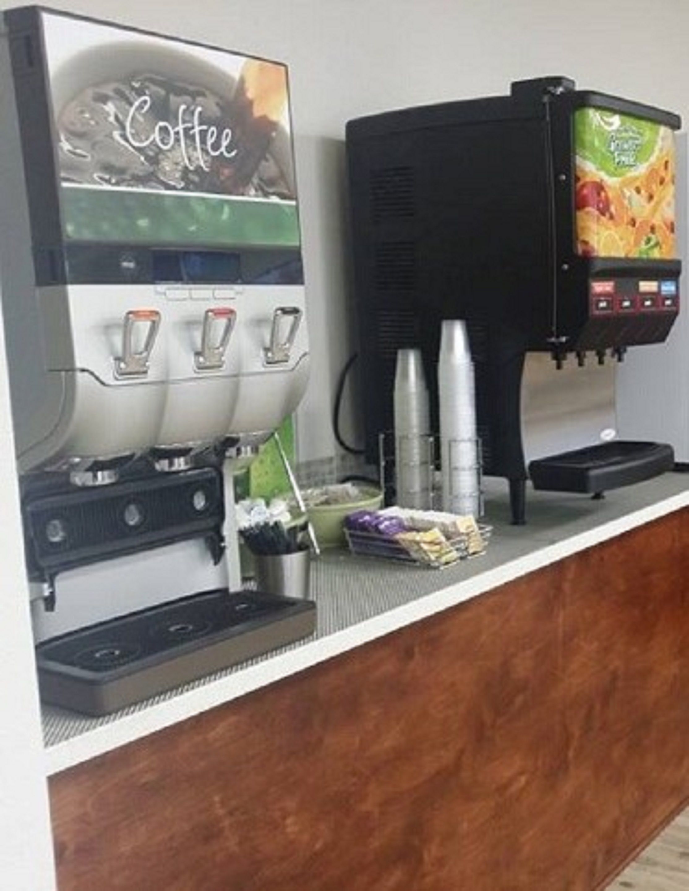 Una estación de café con una máquina de café y un dispensador de bebidas.