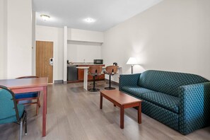 A compact living space with a kitchenette, a dining area, and a seating area with a sofa and a table. - Quality Inn & Suites Schoharie near Howe Caverns (Schoharie)
