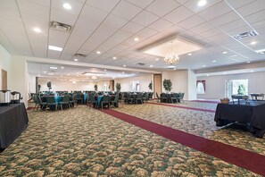 A conference room with multiple tables and chairs, carpeted floor, and ceiling lights. - Quality Inn & Suites Schoharie near Howe Caverns (Schoharie)