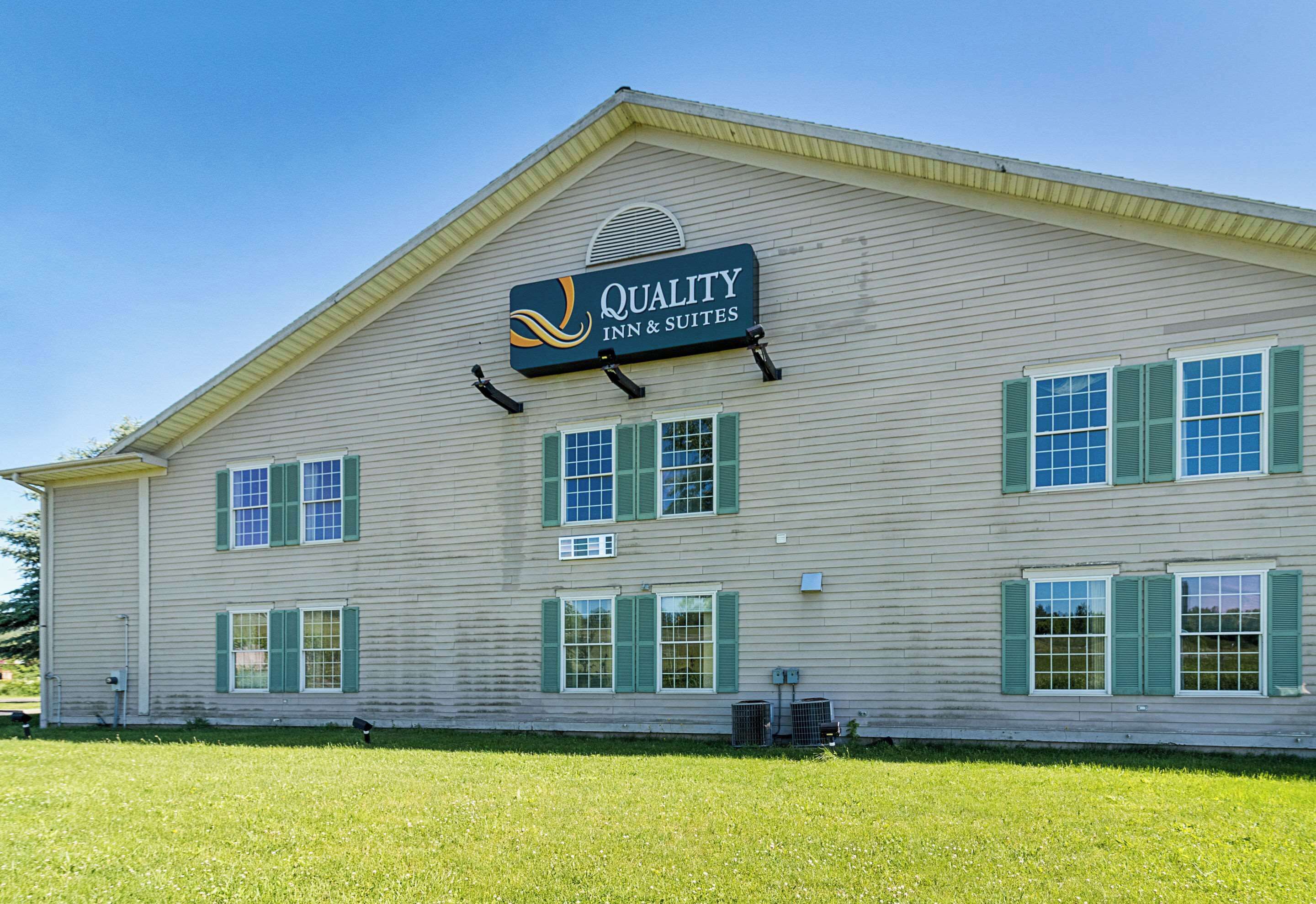 Un edificio de dos pisos con un letrero que dice 'Quality Inn & Suites'.