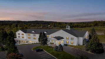 A large, multi-story hotel with a covered front porch and a parking lot.