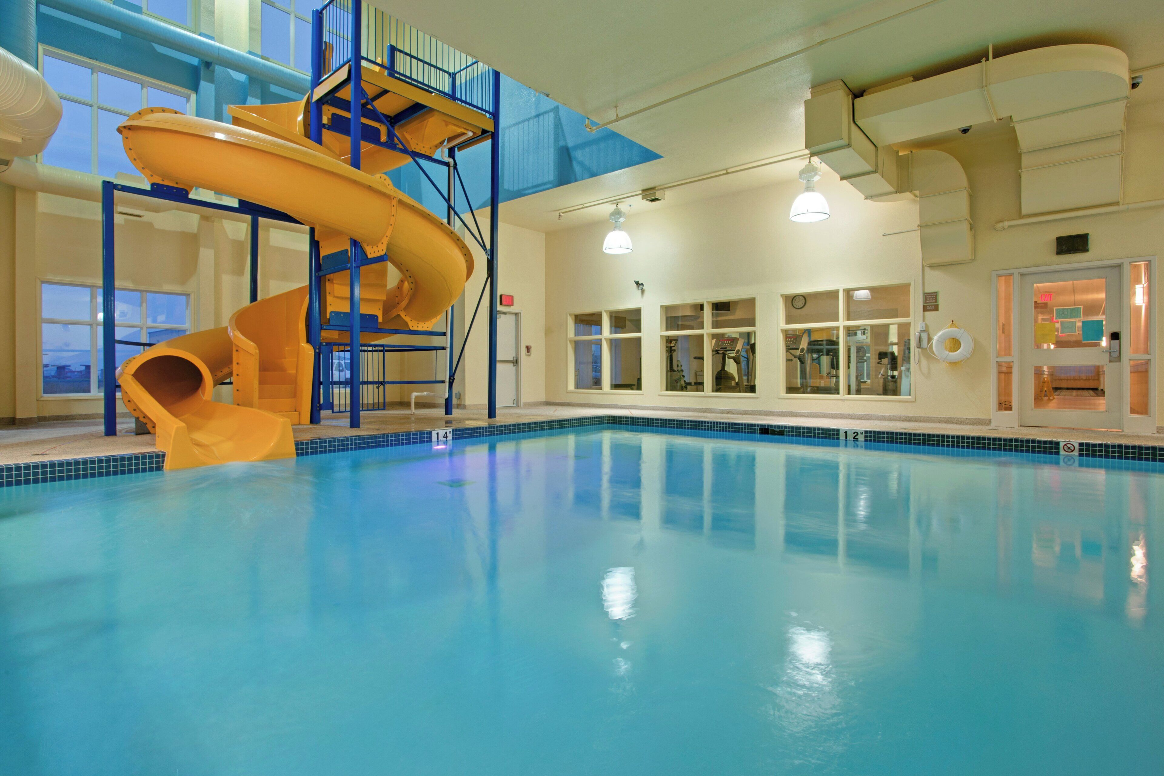 Una piscina interior con un tobogán de varios niveles y una vista despejada del borde de la piscina.