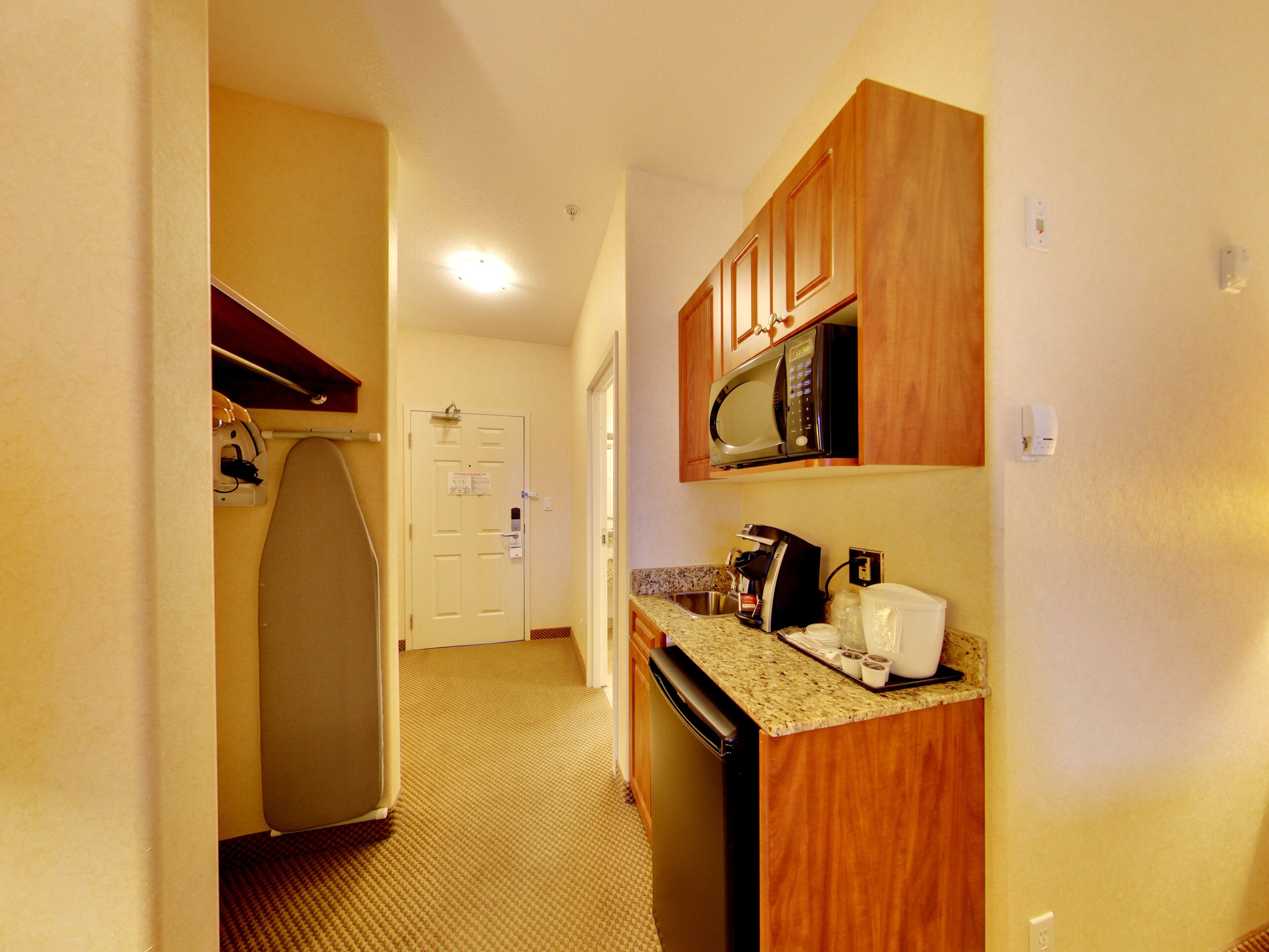 A compact kitchen with a microwave, coffee maker, and dishwasher.