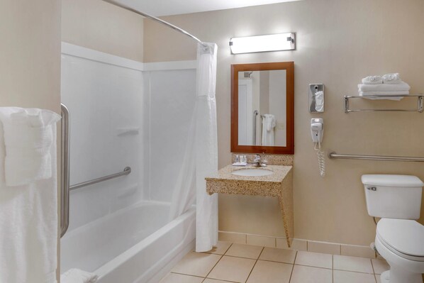 Un baño con ducha, inodoro, lavamanos y espejo.