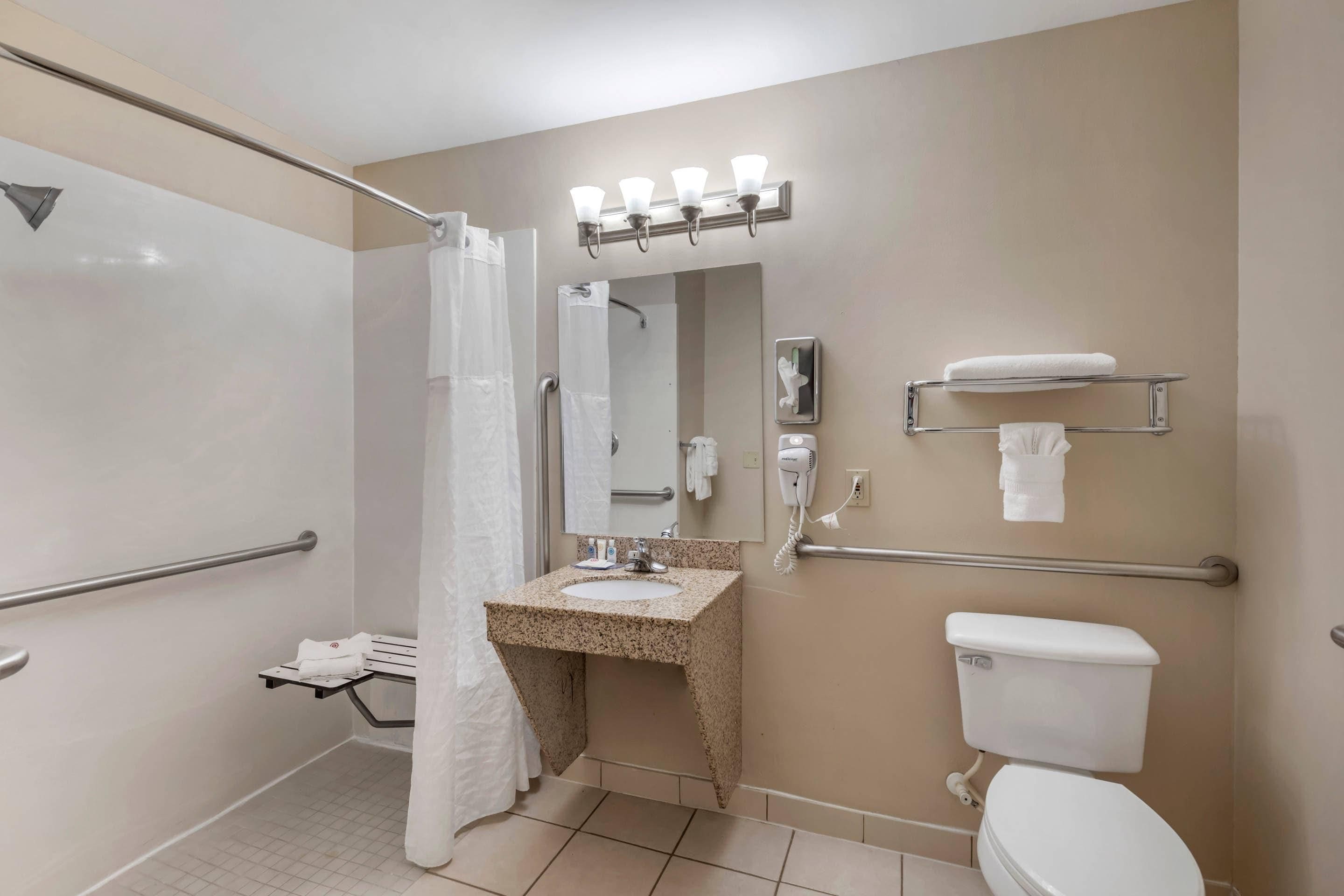 Une salle de bain équipée d’une douche, de toilettes, d’un lavabo et d’un porte-serviettes.