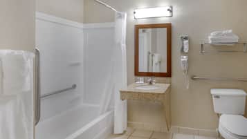 A bathroom with a shower, toilet, sink, and a mirror.