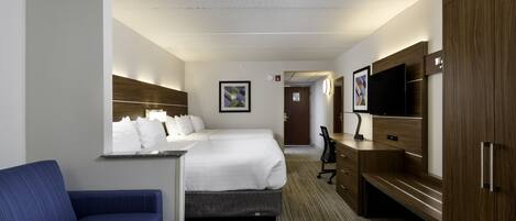 Habitación de hotel con cama, escritorio, silla, televisor y armario.