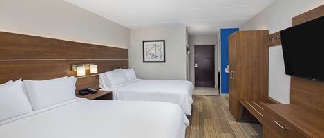 A hotel room with two beds, a wooden wardrobe, a flat-screen TV, and a framed artwork on the wall.