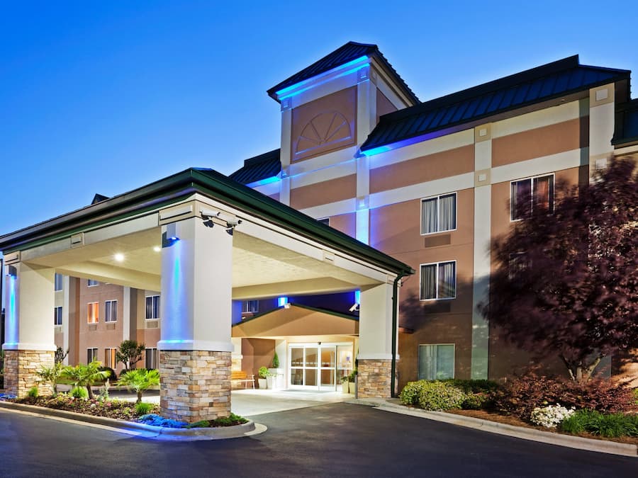 A hotel with a covered entrance, stone pillars, and a clock tower.
