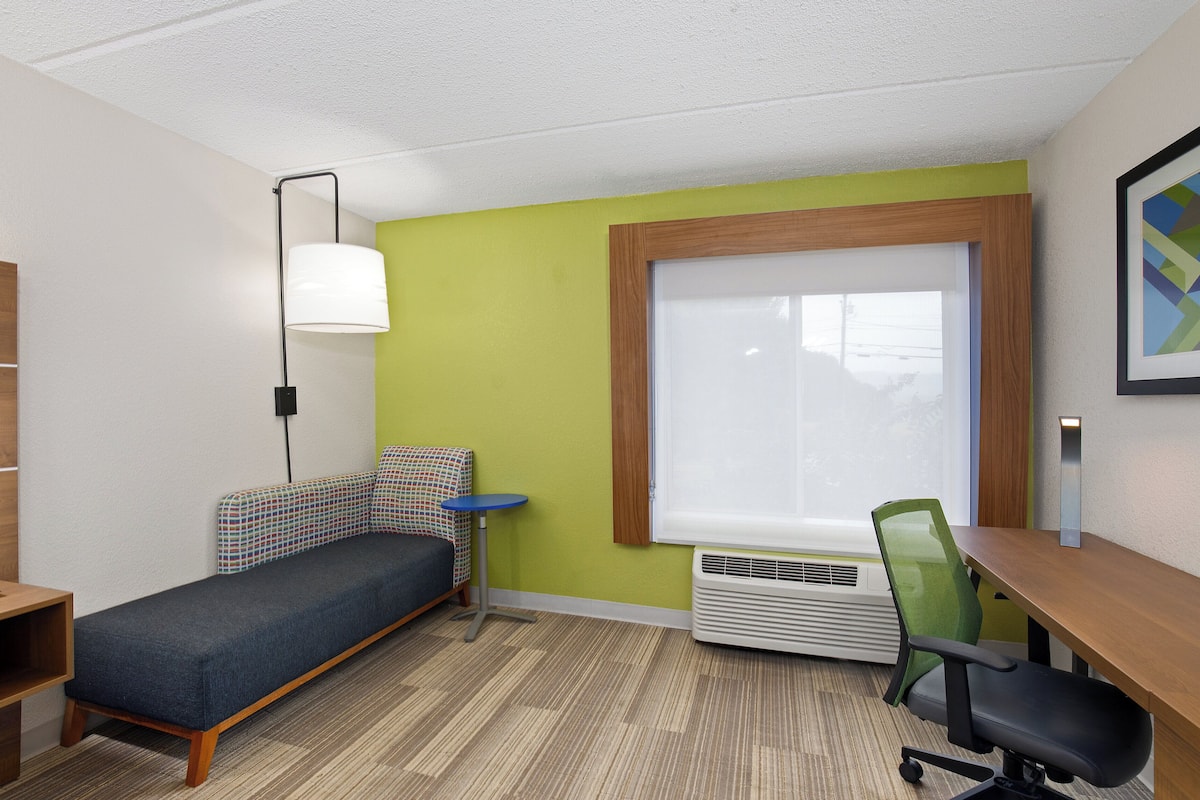 Escritorio, cortinas blackout y tabla de planchar con plancha