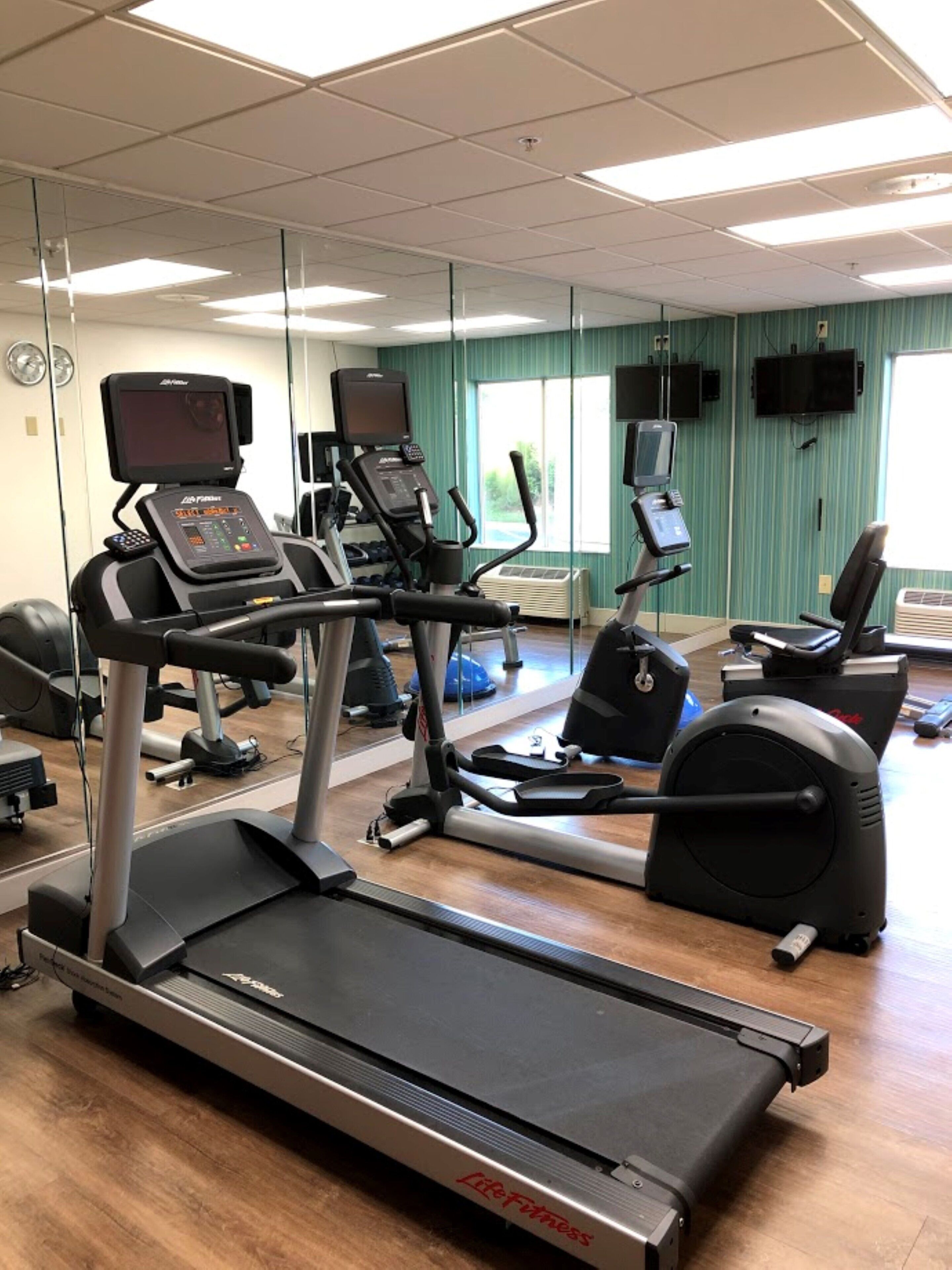 Un centre de remise en forme équipé de tapis de course, de vélos d’appartement et d’appareils d’exercice.