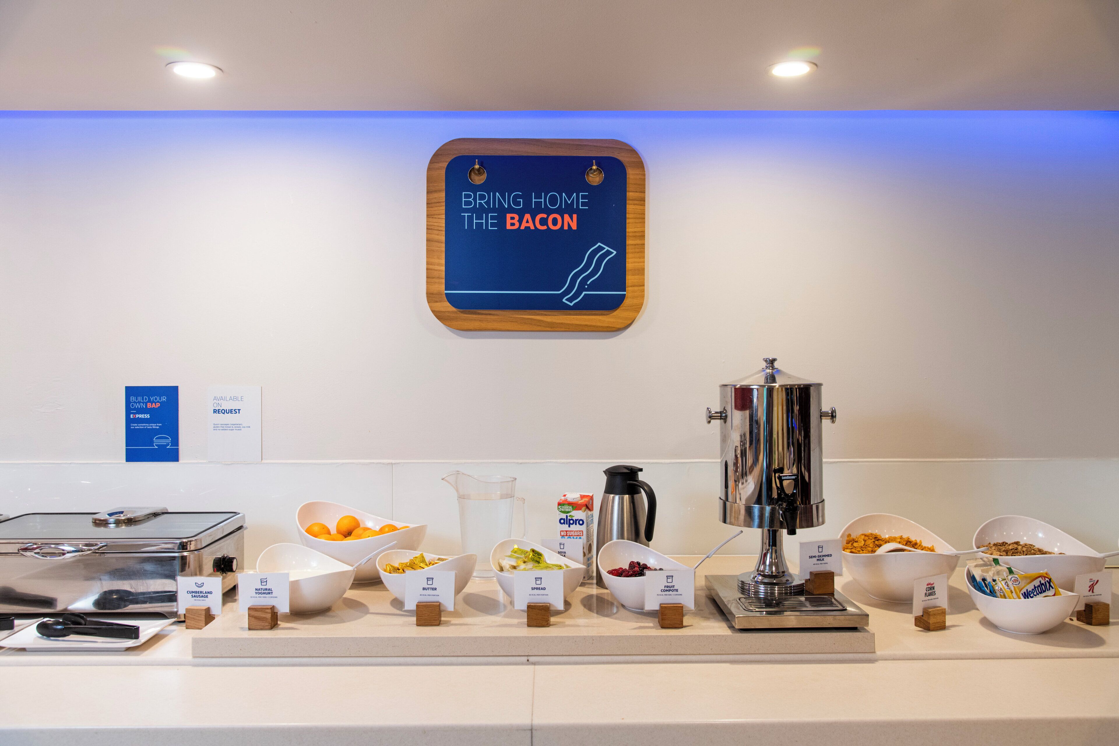 A breakfast buffet area with various food items and a coffee machine.