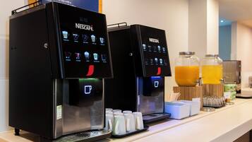 Two Nescafe coffee machines with a selection of coffee options and a water dispenser.