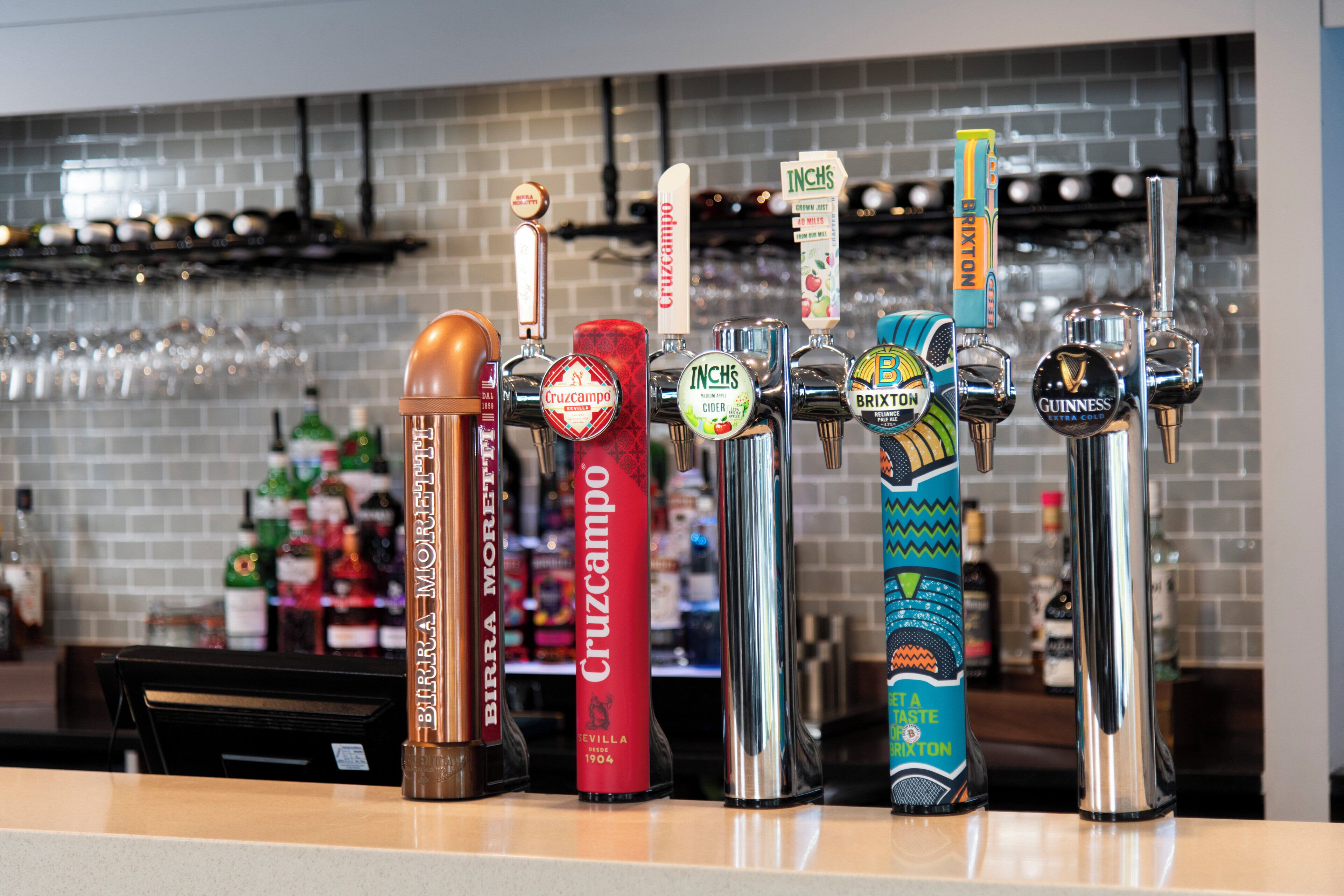A bar with multiple taps, including brands like Cruzcampo, InChS, and Guinness.