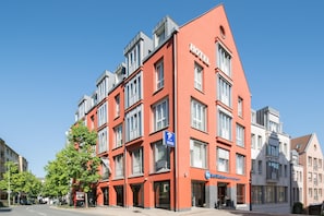 A red hotel building with multiple floors and a prominent 'HOTEL' sign.
