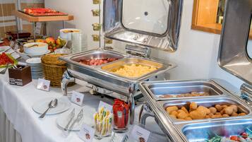 Ein Buffet mit verschiedenen Speisen, darunter Fleisch, Käse und Snacks.