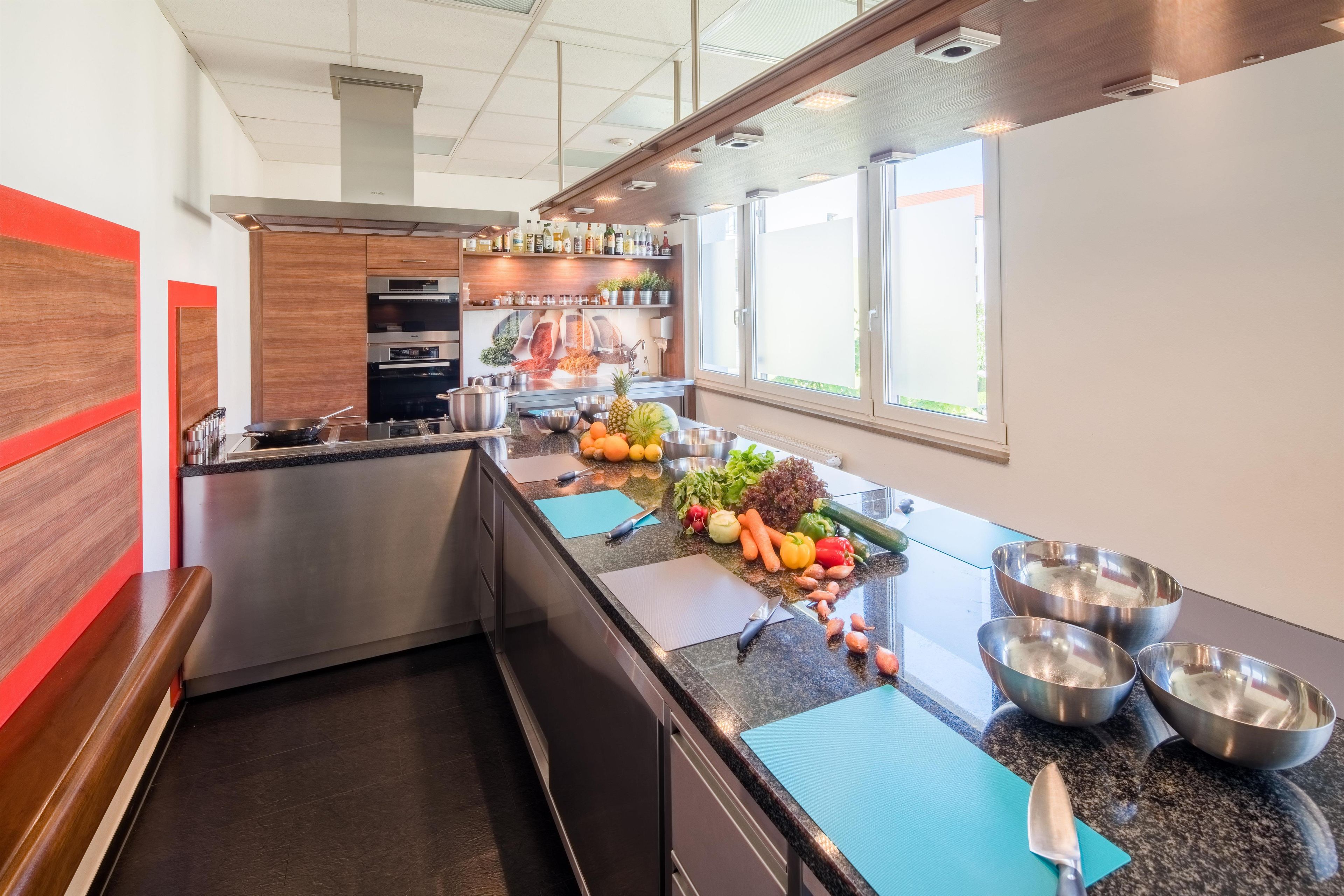 A modern kitchen with stainless steel appliances, a granite countertop, and a variety of fresh produce.
