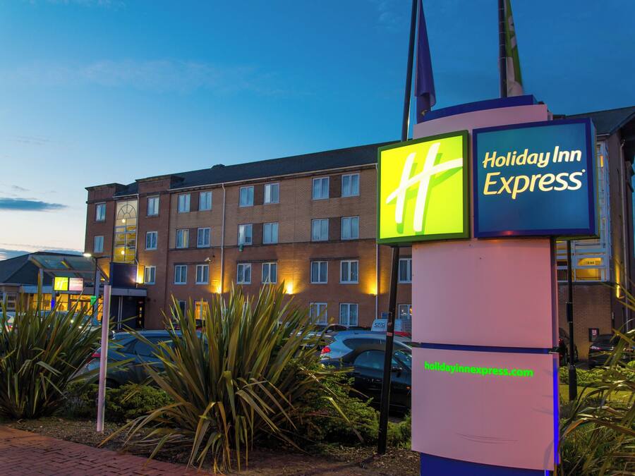 Ein Schild von Holiday Inn Express mit freier Sicht auf das Gebäude im Hintergrund.