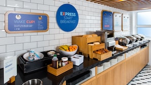 A breakfast buffet area with coffee options, a sign for 'Express Start Breakfast', and a 'Wake Cup' sign offering fairtrade coffee. - Holiday Inn Express Cardiff Bay by IHG (Cardiff)