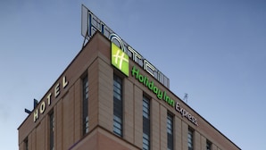 Een Holiday Inn Express hotel met een bakstenen gevel, meerdere ramen en vlaggen.