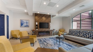 A modern living room with a fireplace, comfortable seating, and a large window. - Holiday Inn Express Breezewood by IHG (Breezewood)