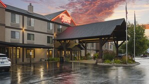 Un hotel con entrada cubierta, varias ventanas y un letrero de neón.