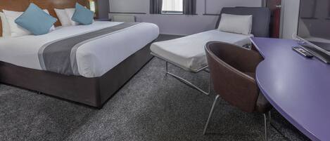 Habitación de hotel con una cama grande, una cama más pequeña, un escritorio y una silla.