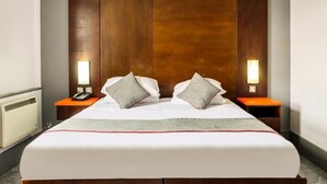 A hotel room with a large bed, wooden headboard, two bedside tables with lamps, and a telephone. - Sheffield Metropolitan Hotel by Belvilla (Sheffield)