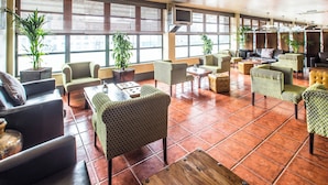 A spacious lobby with multiple seating areas, large windows, and potted plants. - Sheffield Metropolitan Hotel by Belvilla (Sheffield)