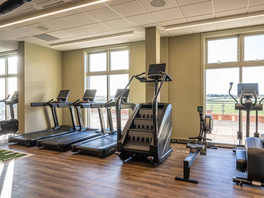 A gym with treadmills, elliptical machines, and a rowing machine.