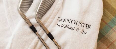 A white towel with "Carnoustie Golf Hotel & Spa" embroidered on it, placed on a checkered surface.