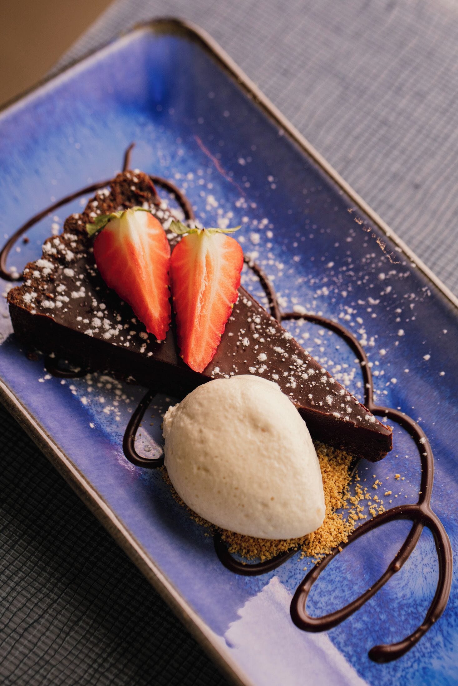 A dessert plate with chocolate cake, strawberries, and ice cream.