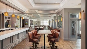 A spacious bar area with a long counter, multiple seating options, and pendant lighting. - Carnoustie Golf Hotel (Carnoustie)