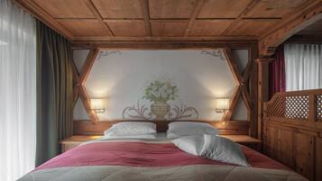 A wooden-framed bedroom with a bed, two bedside lamps, and a decorative wall panel.