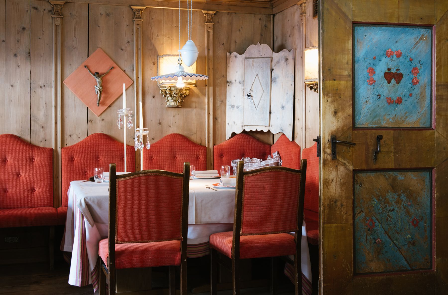 A dining area with red upholstered chairs and a white tablecloth.