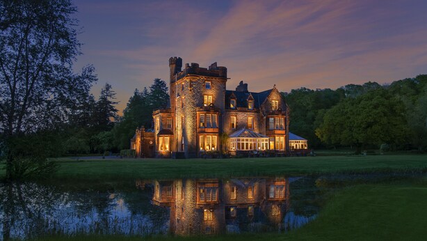 A large, castle-like building with multiple towers and a reflective pond in front. - Isle of Eriska Hotel and Spa (Oban)