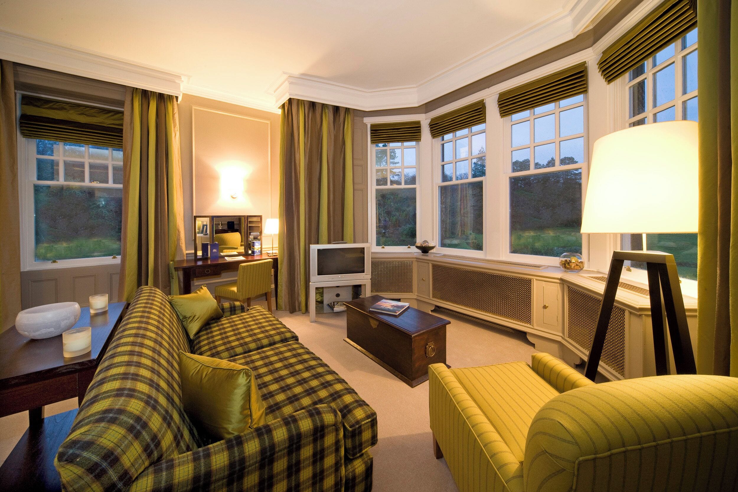 A cozy living room with a sofa, armchair, and a television.