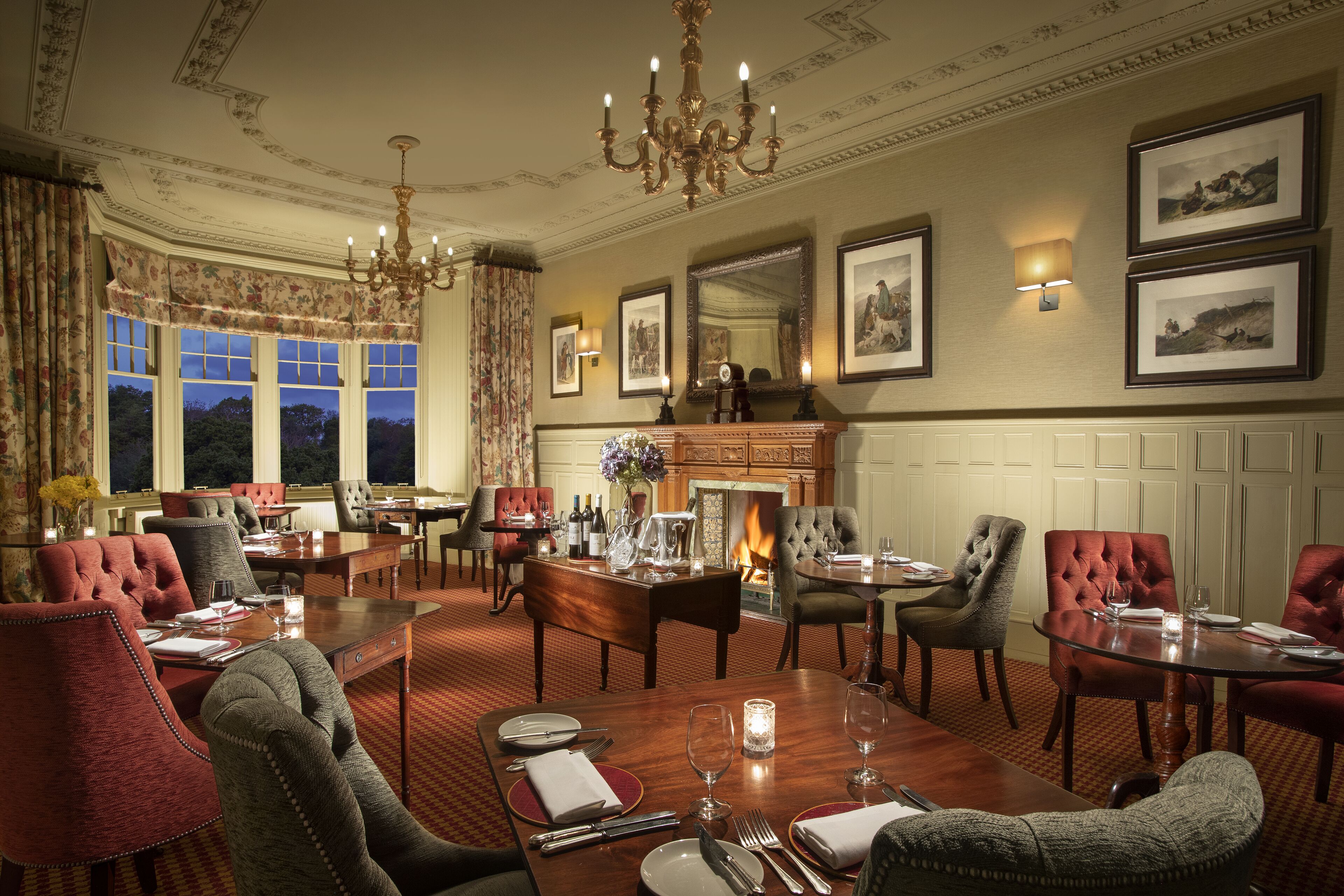 A formal dining room with a fireplace, elegant chairs, and a chandelier.