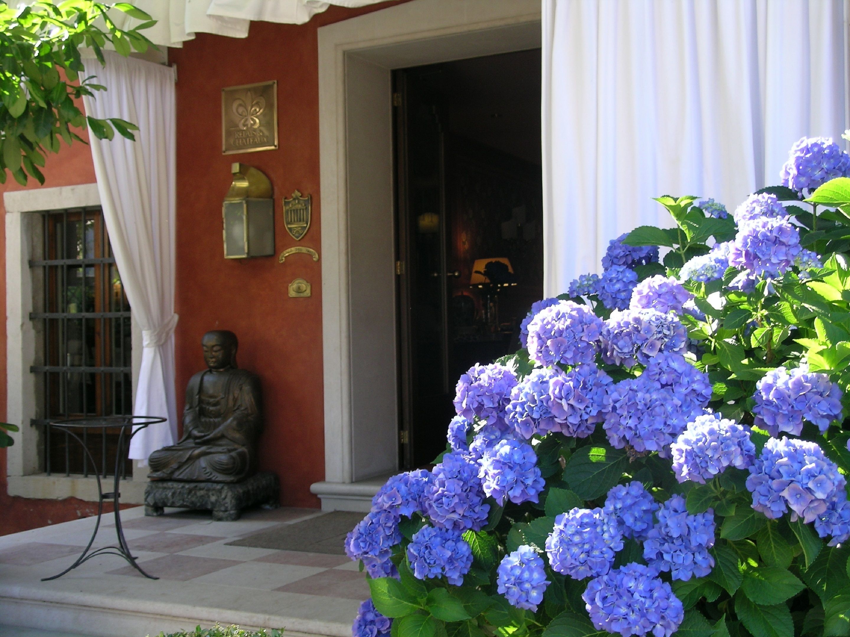 Una estatua de Buda, una placa y una puerta con cortinas.