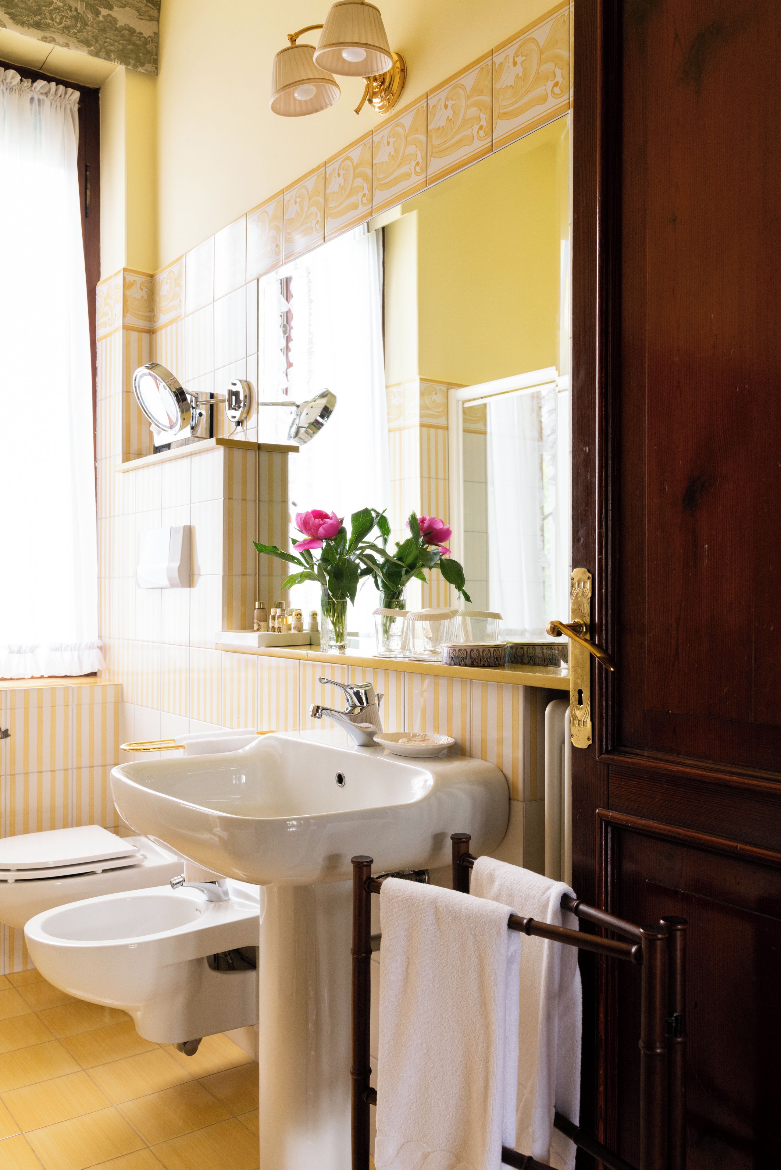 A bathroom with a sink, mirror, and a wooden door.