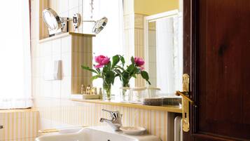 A bathroom with a sink, mirror, and a wooden door.