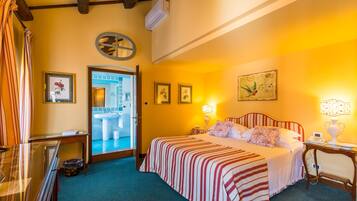 A hotel room with a bed, bedside table, lamp, and a view of the bathroom.