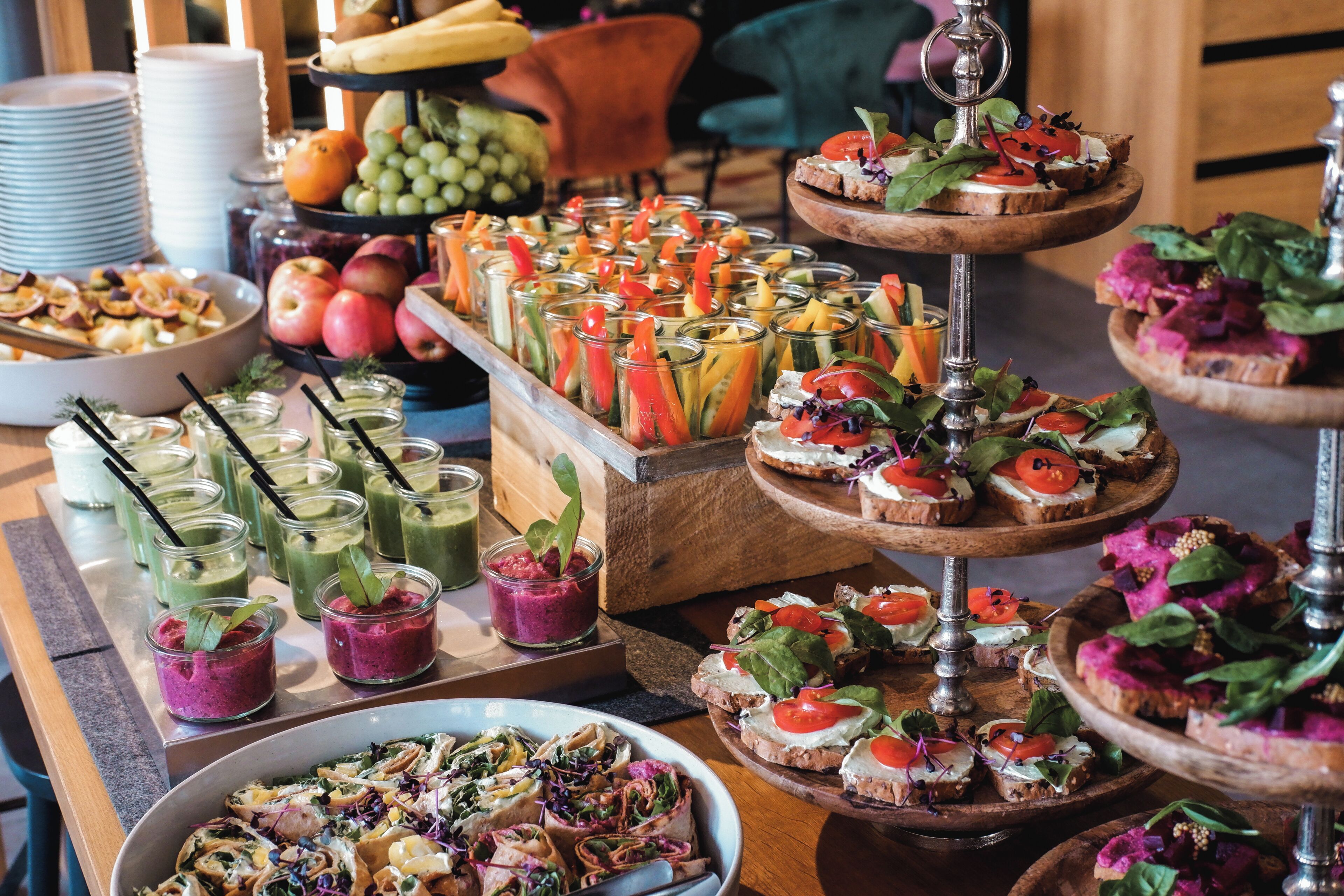 A buffet with various food items, including sandwiches, fruits, and drinks.