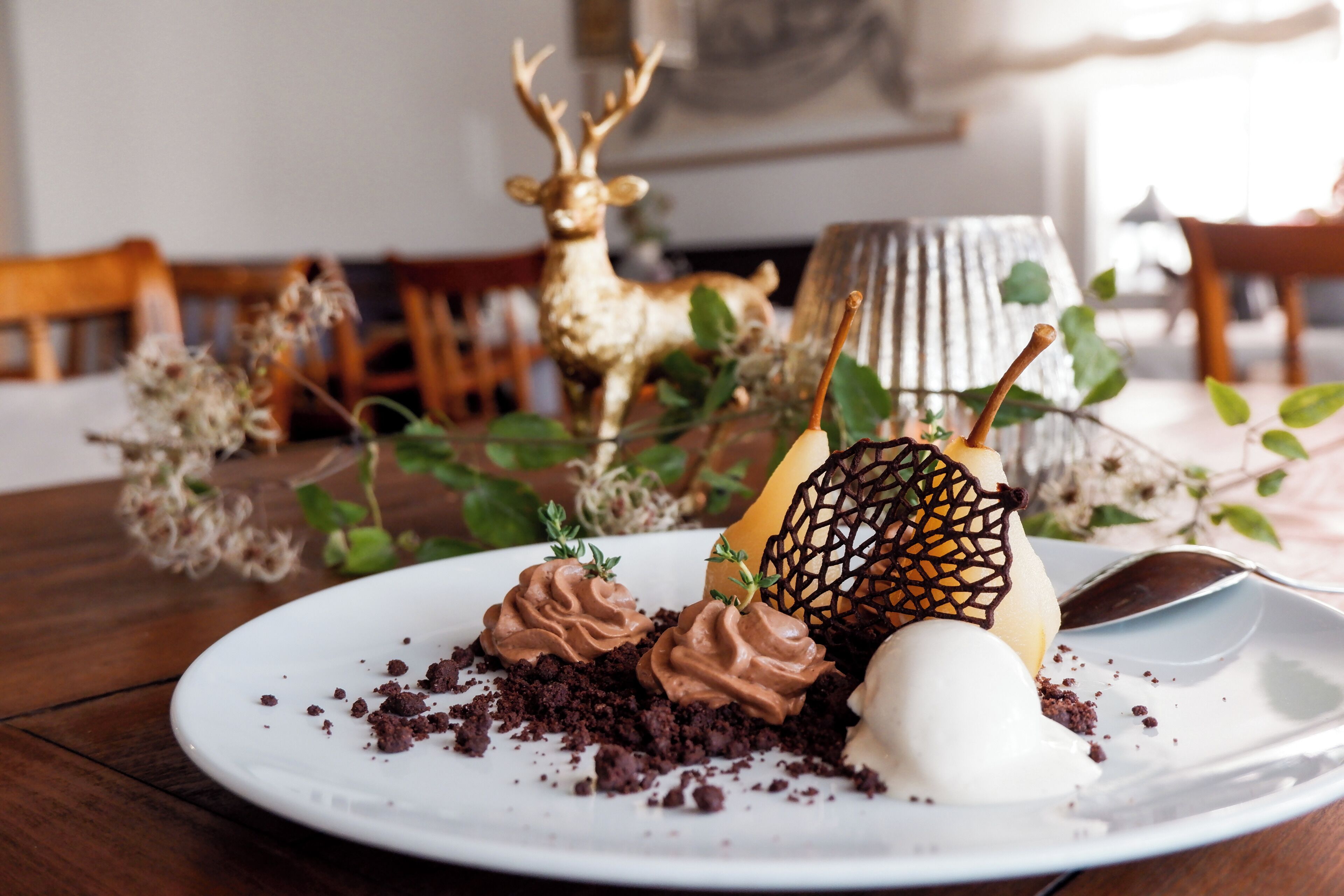 A dessert plate with chocolate mousse and a chocolate lattice on a white plate.